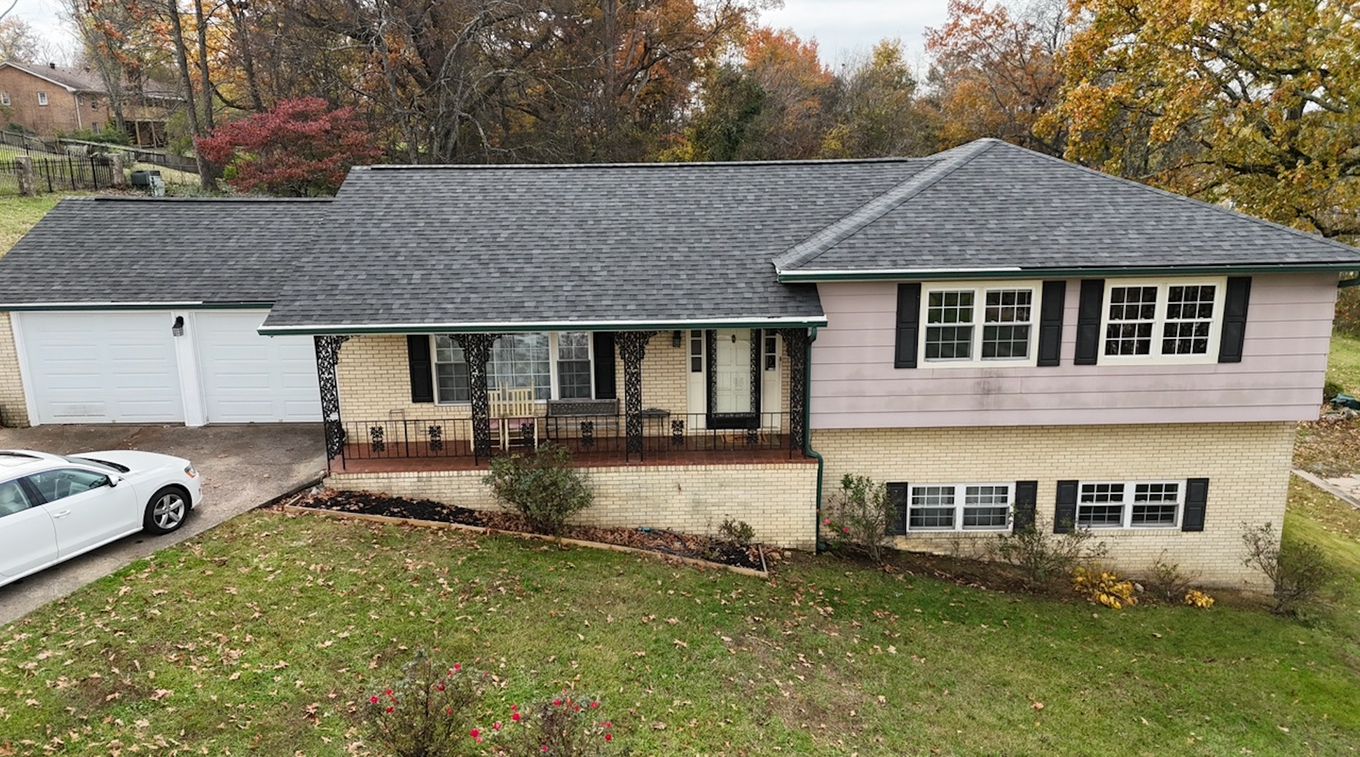 An aerial view of a house with a limousine parked in front of it.