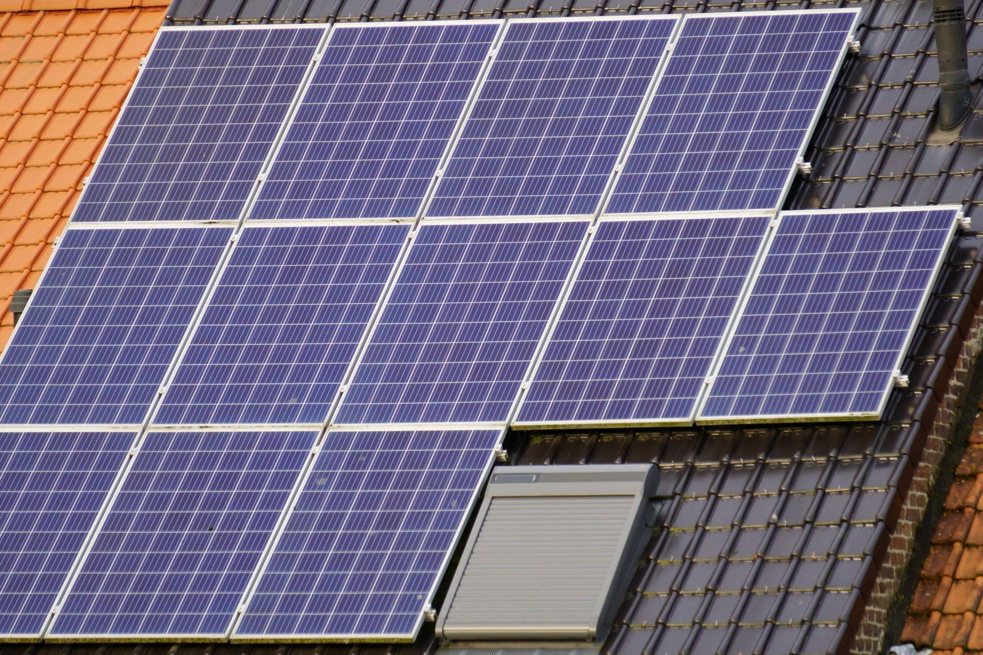 Solar panels mounted on a rooftop, covering most of the roof in blue-black rectangles.