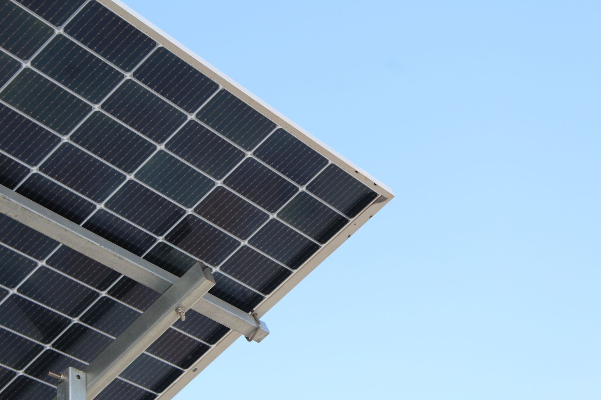Solar panels mounted on a metal frame against a clear blue sky