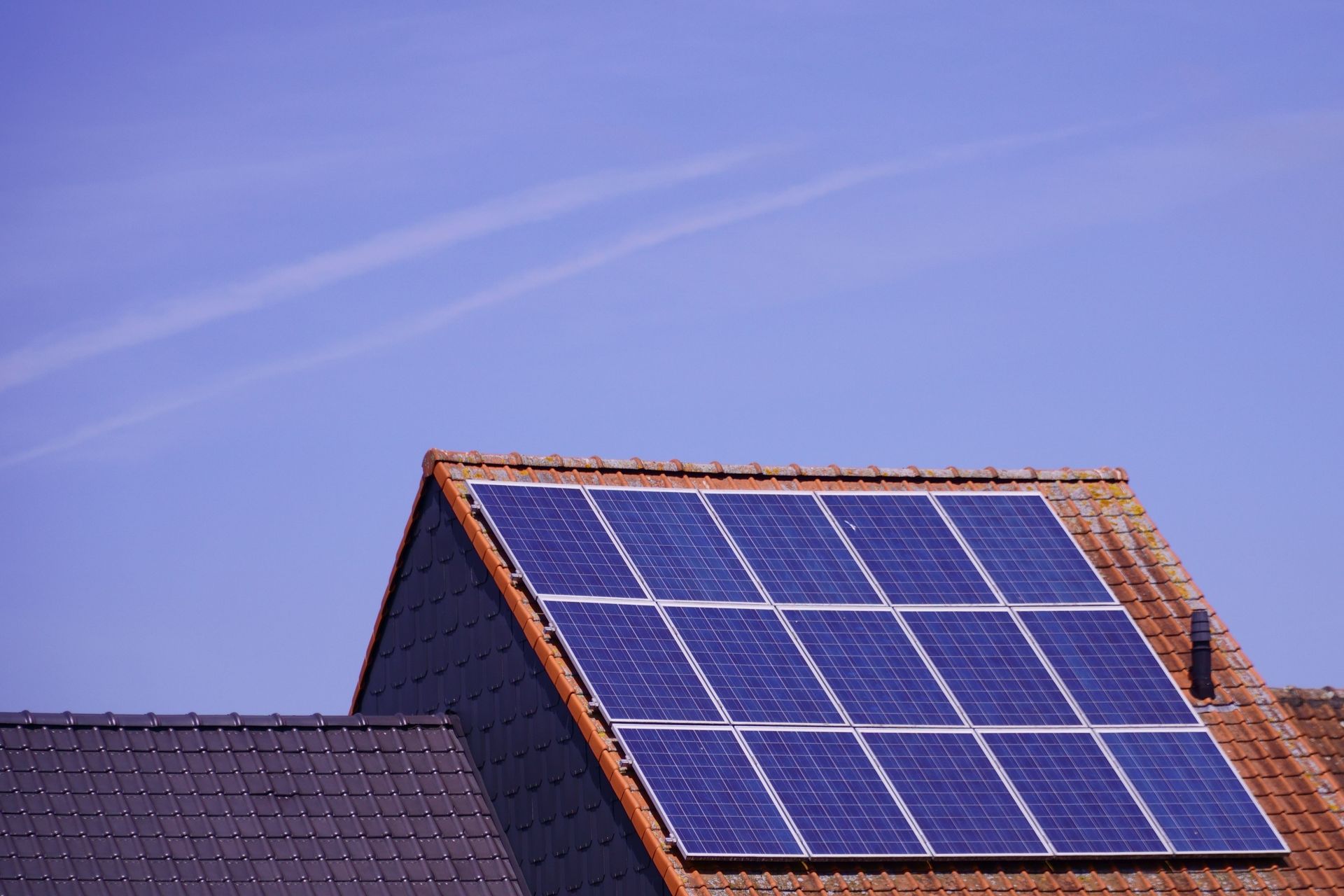 Solar panels mounted on a rooftop against a clear blue sky