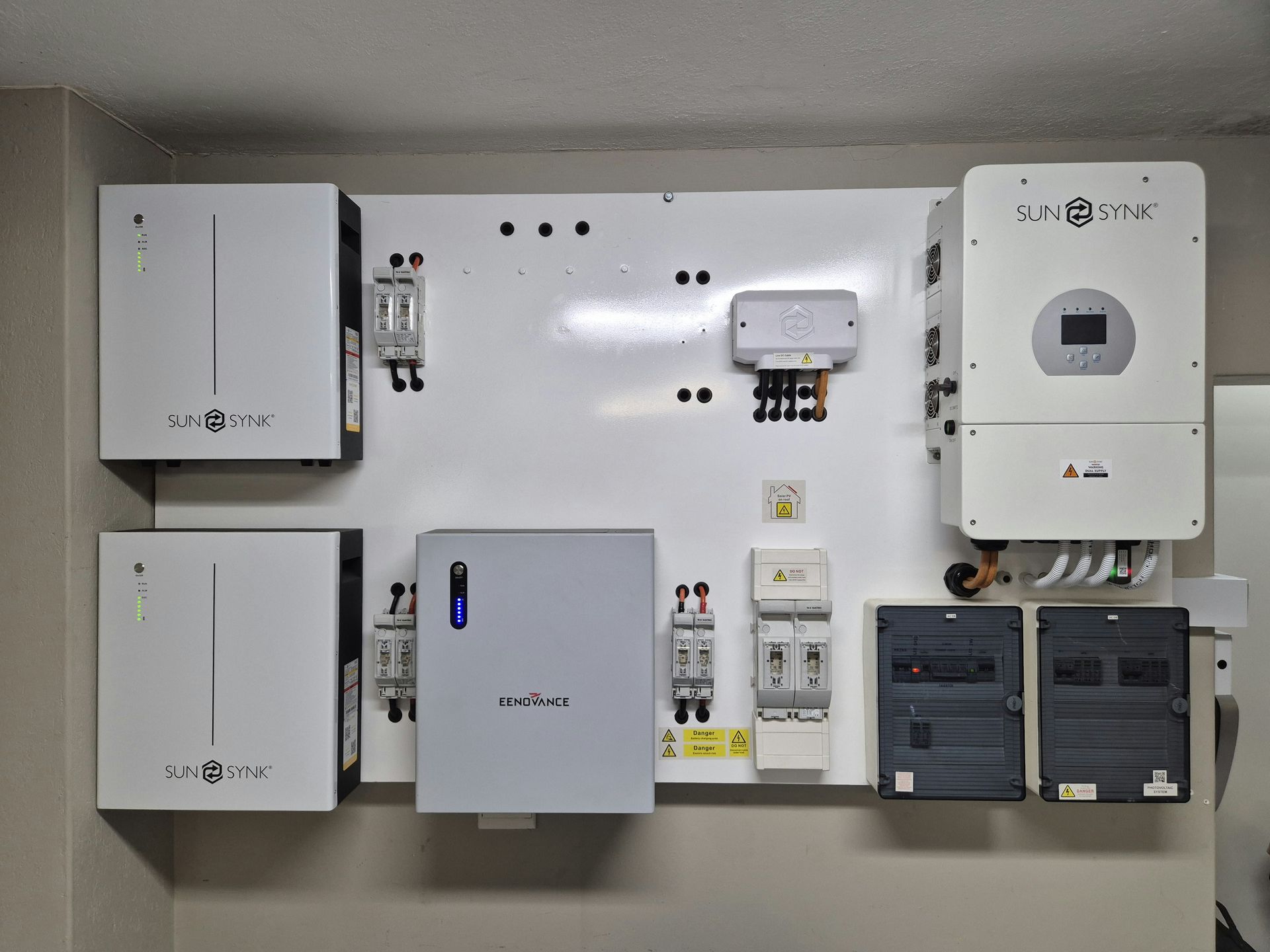 Wall-mounted electrical control boxes and meters in a utility room, mostly white and gray.