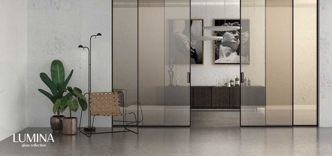 Soggiorno moderno minimalista con parete divisoria in vetro, pianta in vaso, sedia e quadro incorniciato a parete