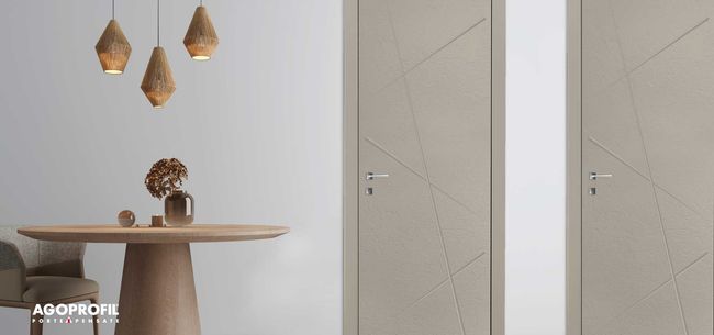 Sala da pranzo minimalista con tavolo rotondo in legno, lampade a sospensione e porte beige su una parete chiara.