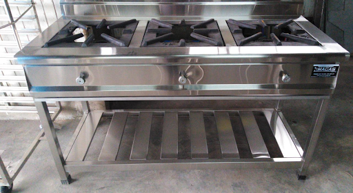 Cocina comercial de acero inoxidable con horno y estante inferior en una cocina