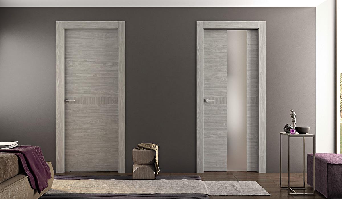 Due porte interne moderne, una con effetto legno e una con pannello smerigliato, contro una parete grigia.