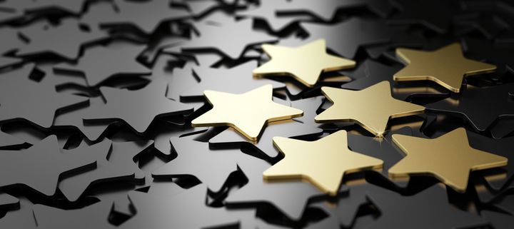 Golden stars stand out from a background of black star-shaped confetti, perhaps signifying achievement.