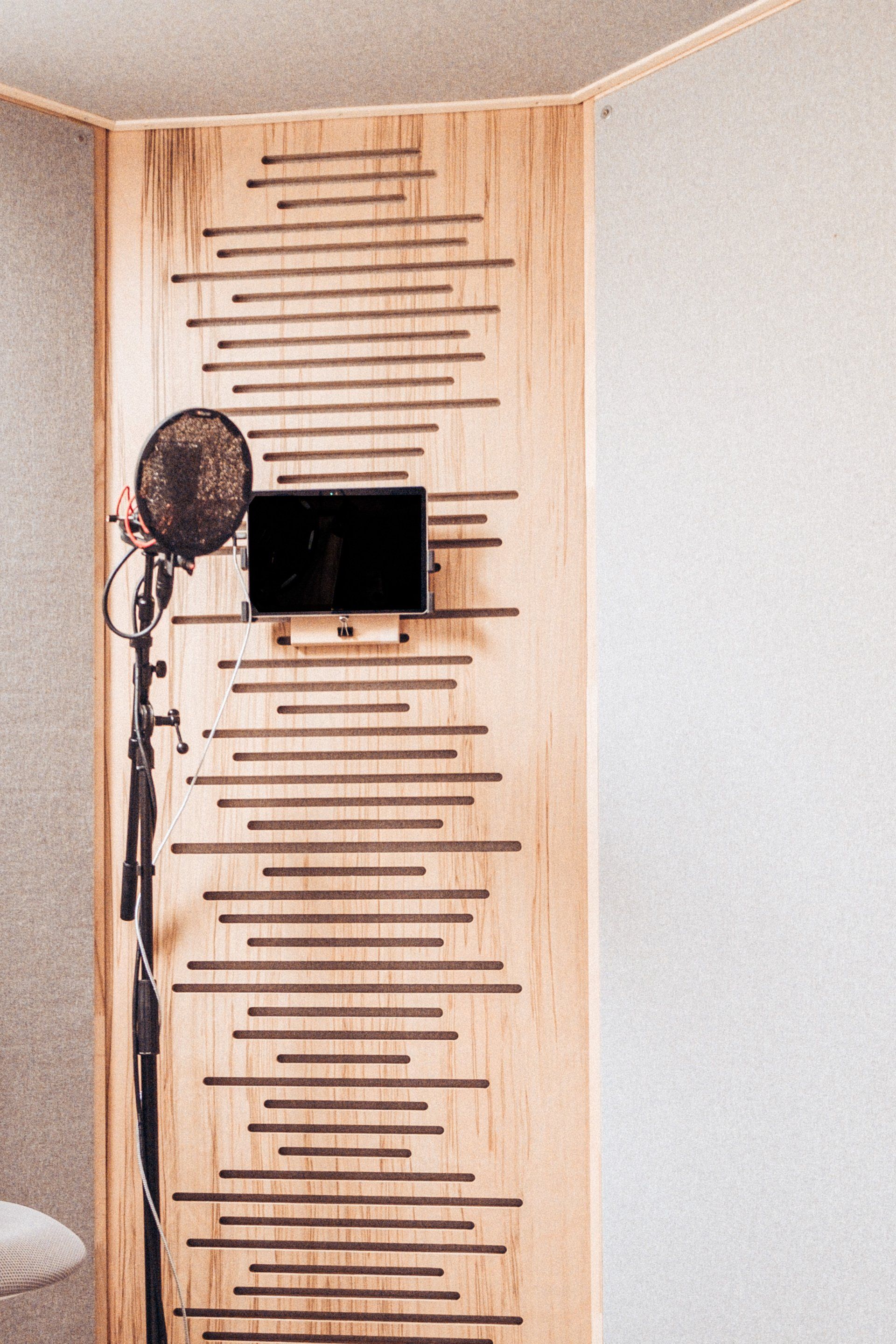 Foto des Sprecherplatzes mit Mikrofon und Bildschirm vor einer Holzwand