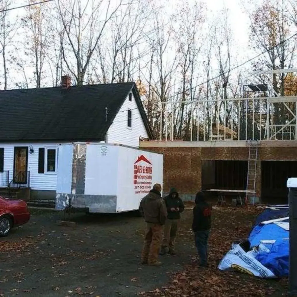 A group of people standing in front of a house that is under construction
