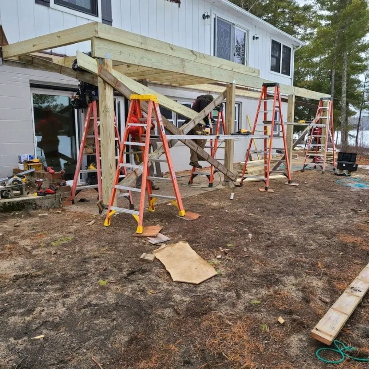 A wooden deck is being built in front of a house.