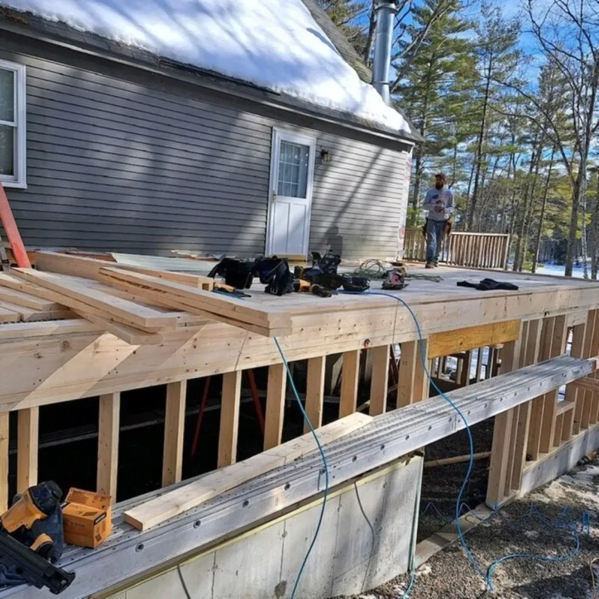 A wooden deck is being built on the side of a house.
