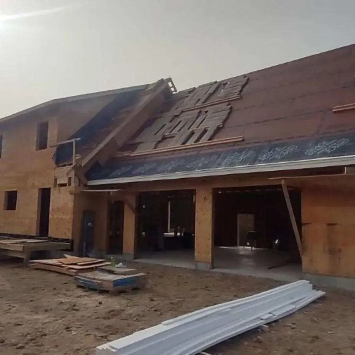 A house is being built with a roof that is being installed