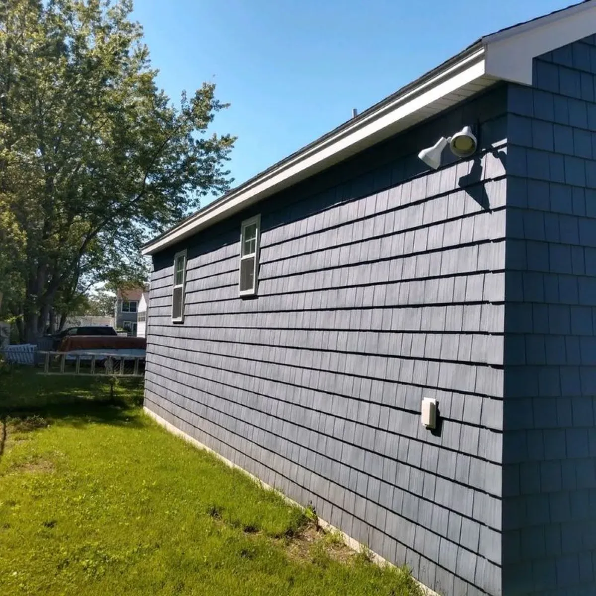 A blue house with shingles on the side of it
