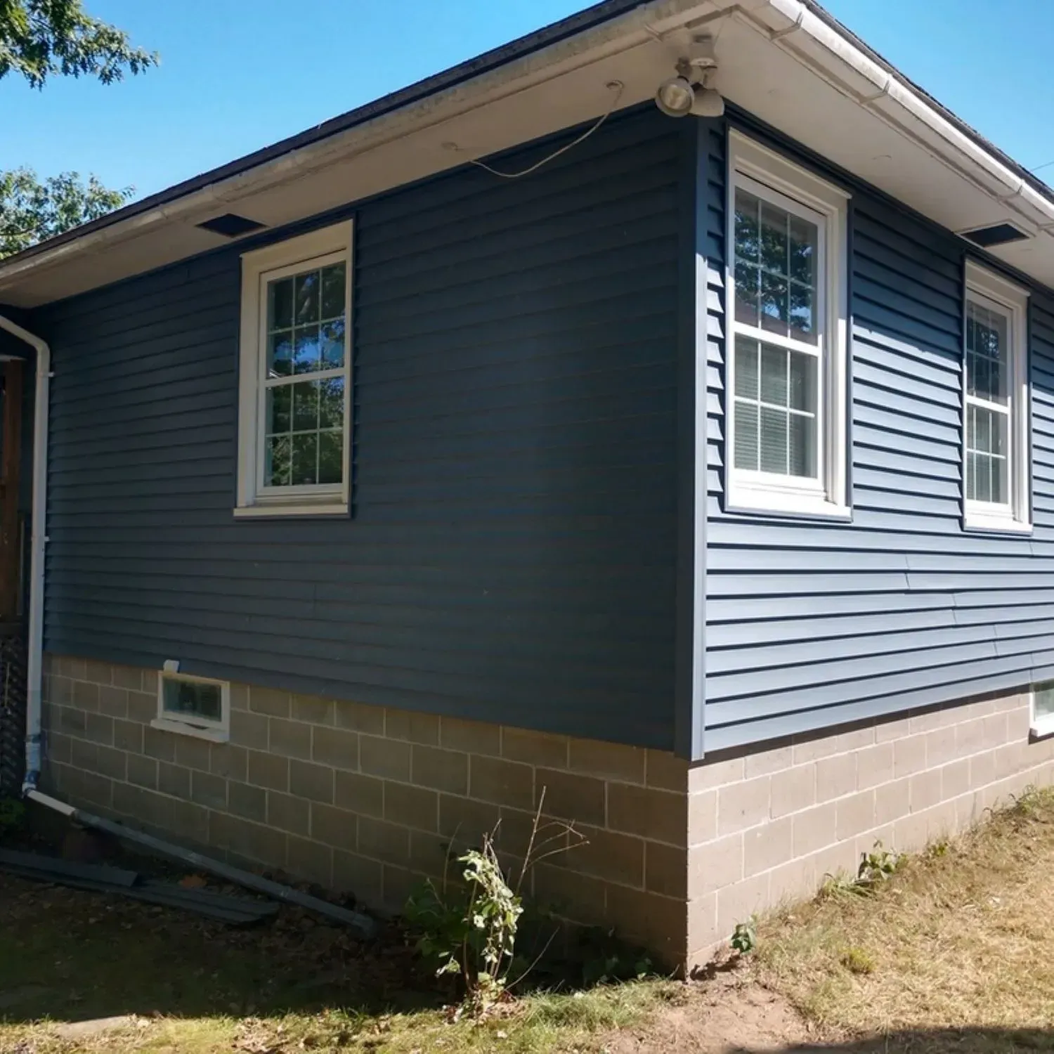 A small house with blue siding and white windows