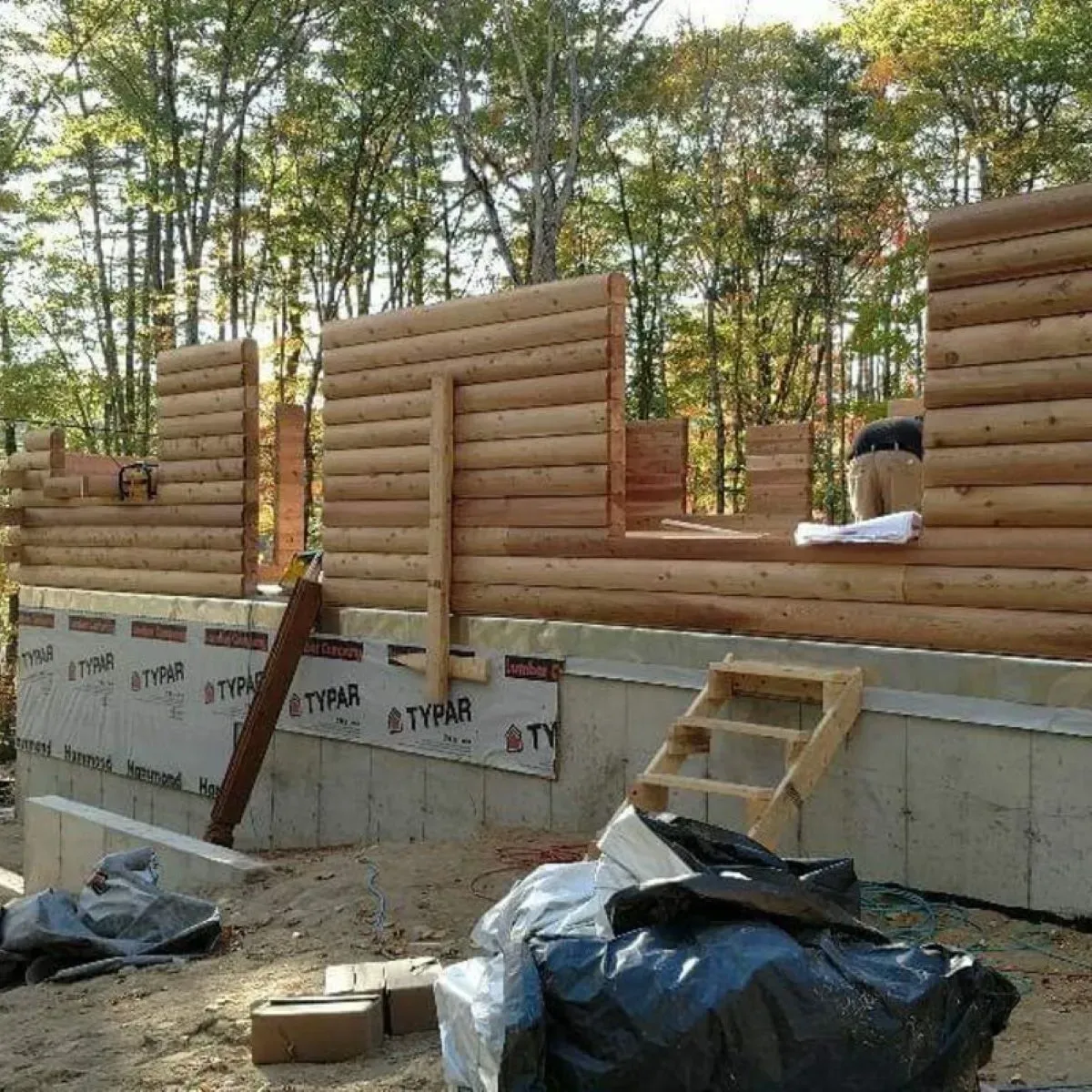 A log cabin is being built in the woods.