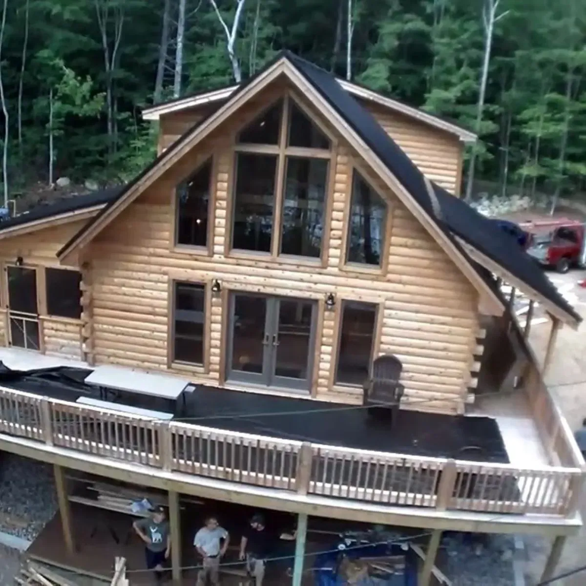 An aerial view of a log cabin with a large deck