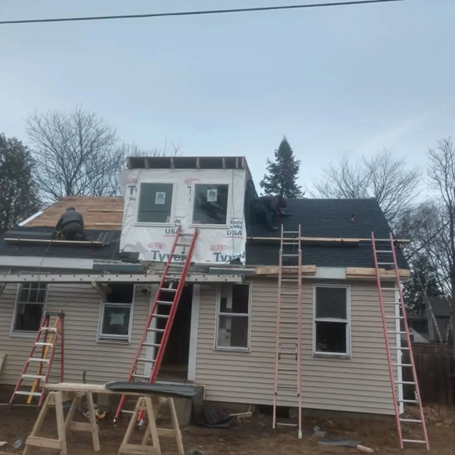 A house is being remodeled with a roof being installed