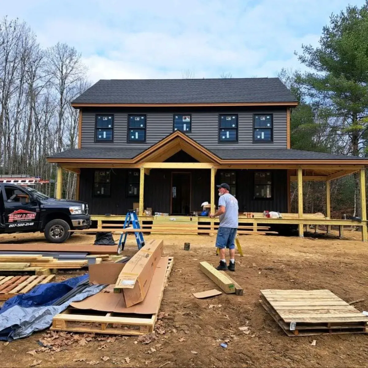 A man is standing in front of a house that is being built