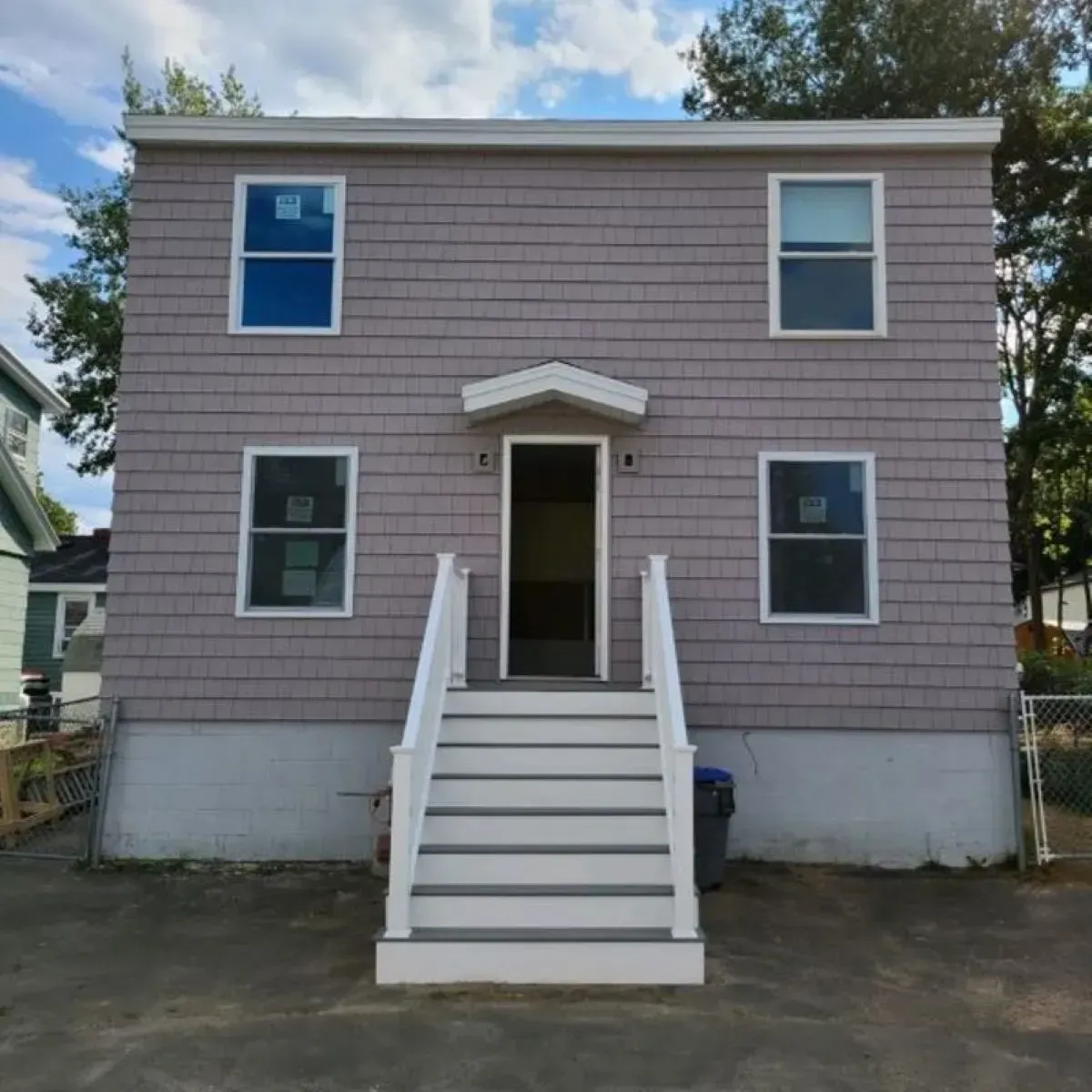 A purple house with white stairs leading up to the front door