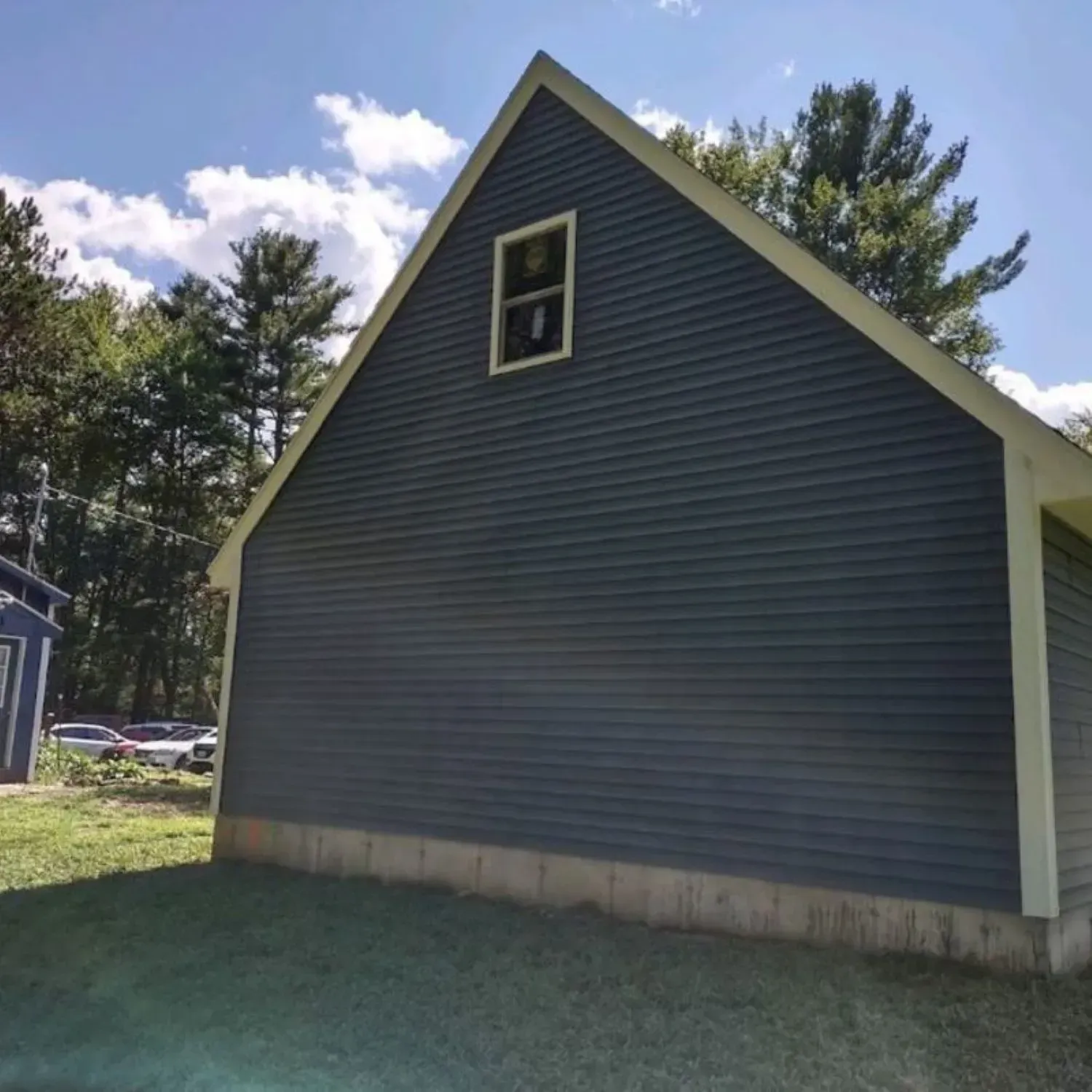 A gray house with a yellow roof and a window