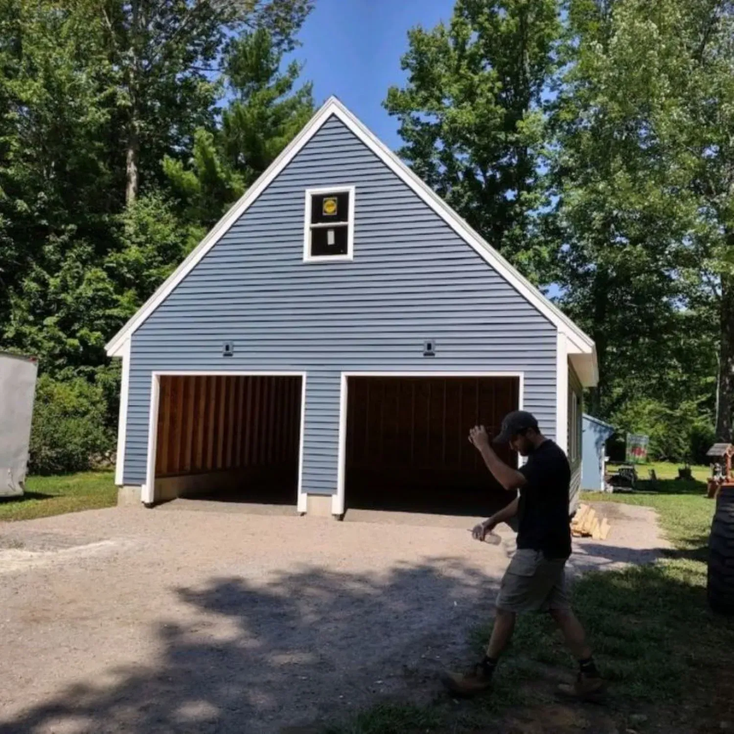 A man walking in front of a blue garage