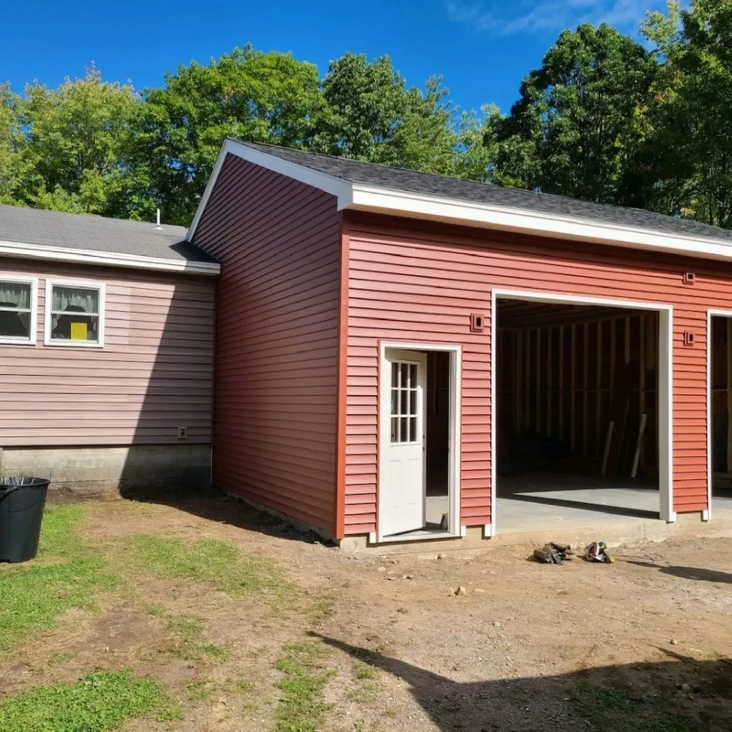 A red garage is being built next to a house