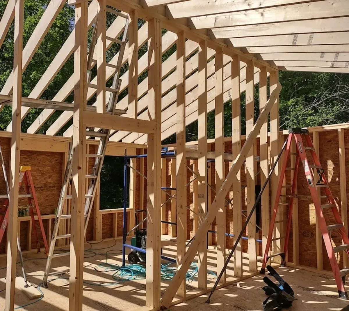A house is being built with wooden beams and ladders.