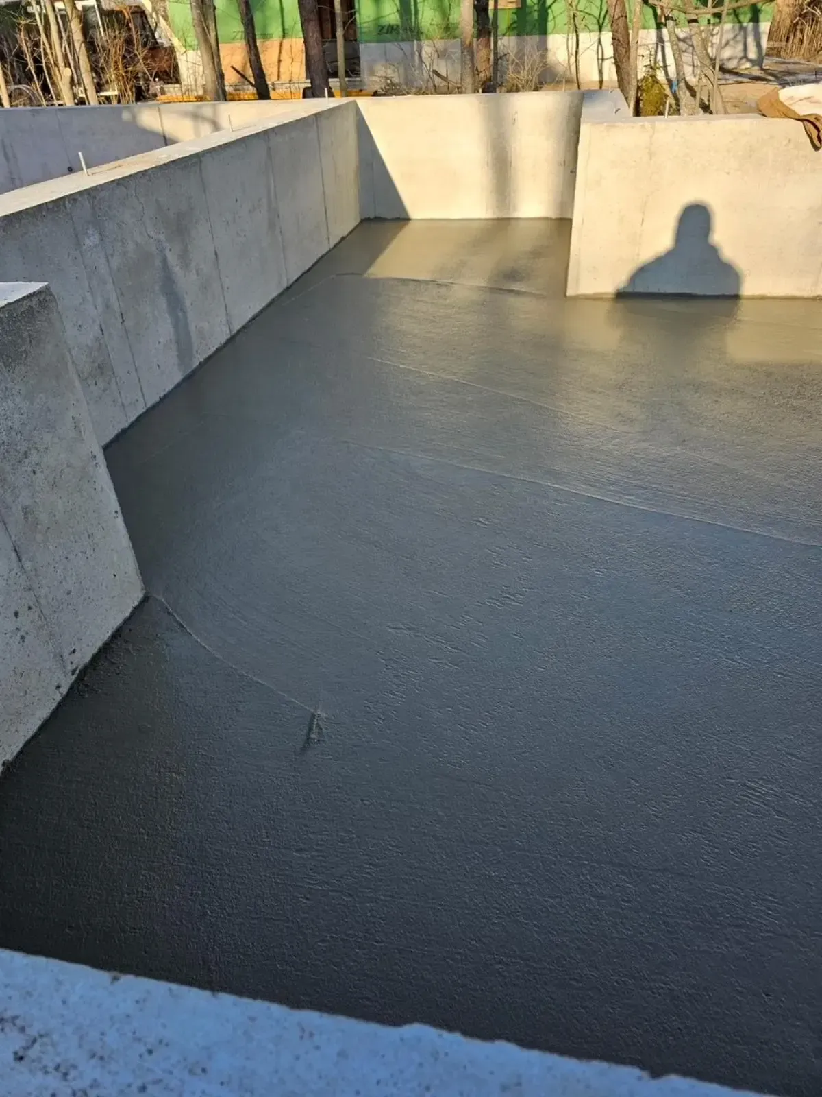 A concrete floor with a shadow of a person on it.