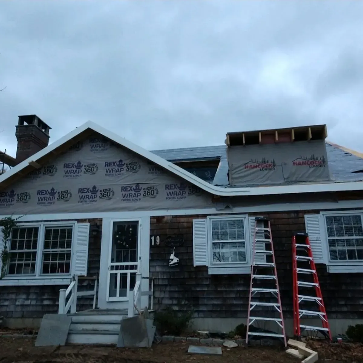 A house that is being remodeled with a ladder in front of it