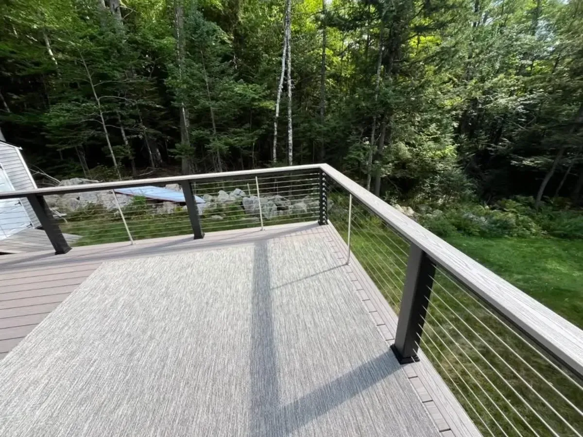 Wooden viewing deck with cable railing overlooking a forest and creek