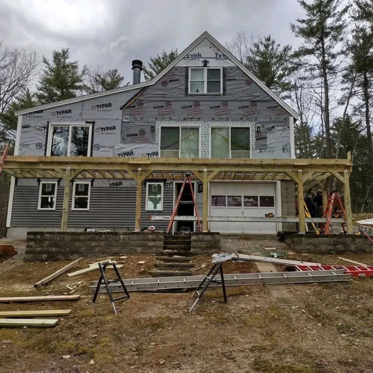 A house is being remodeled with a wooden porch.