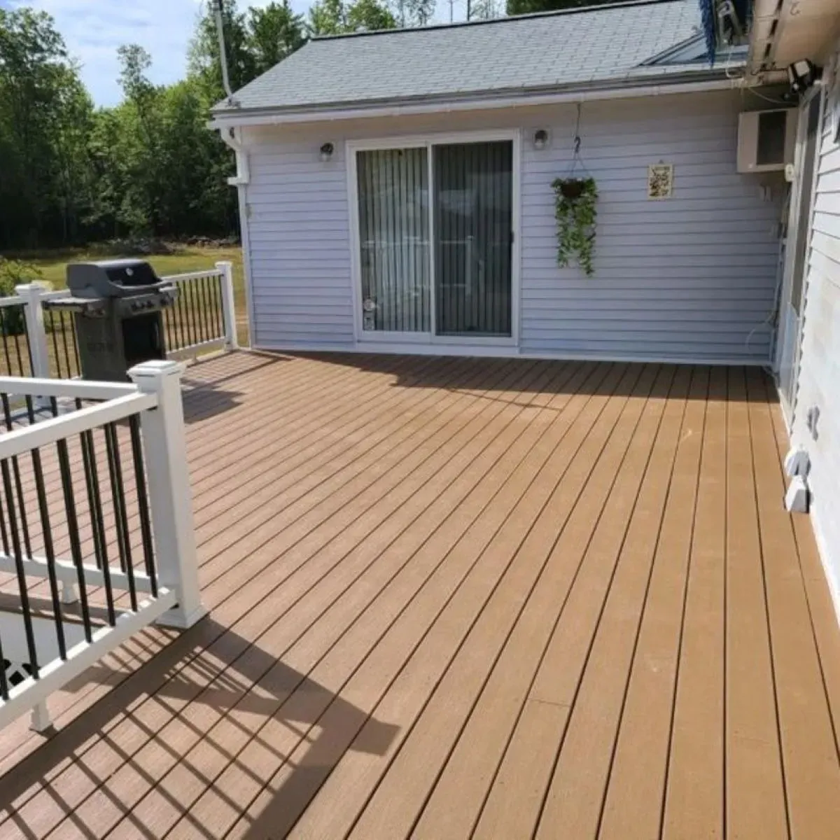 A white house with a brown deck in front of it