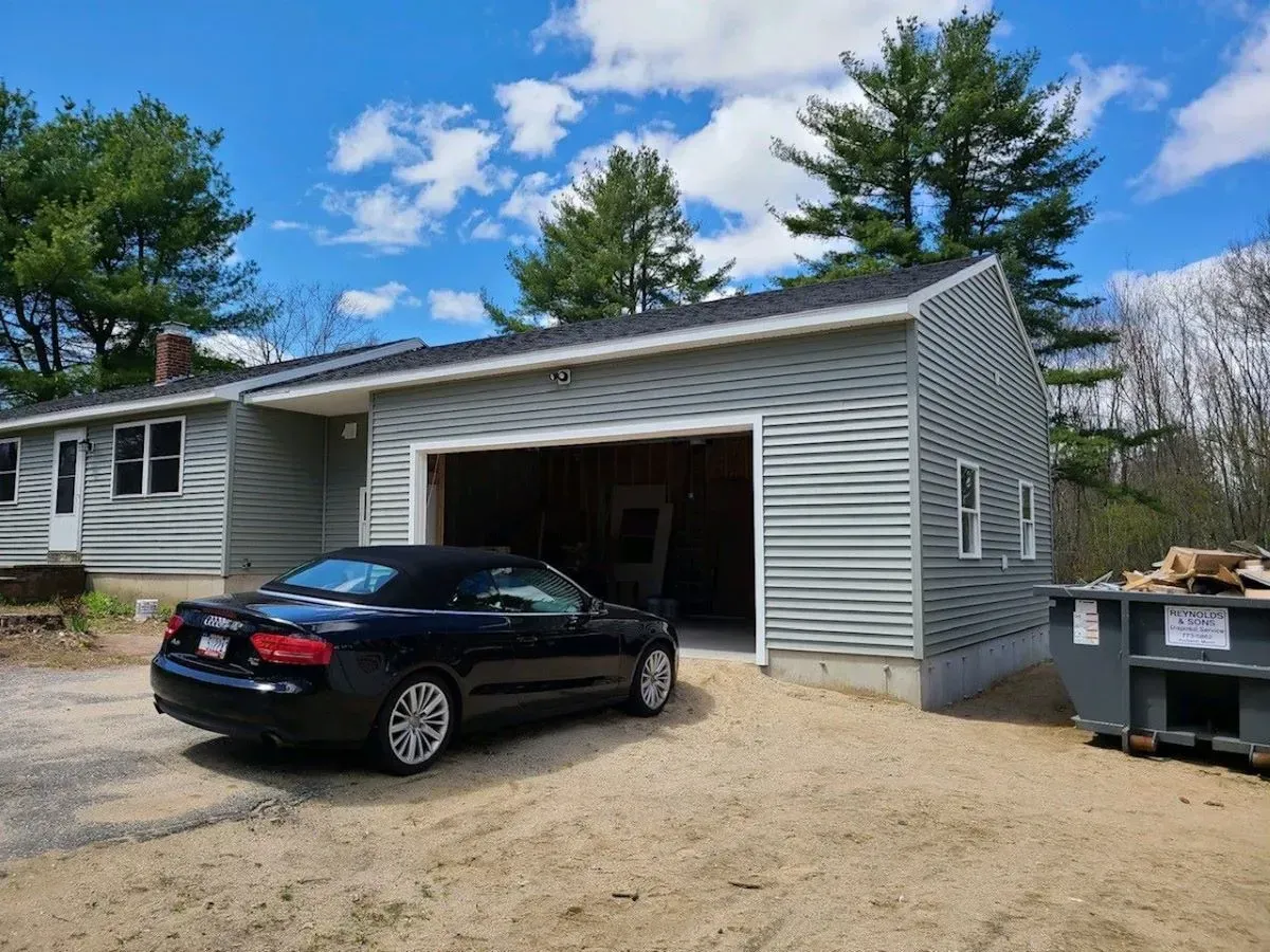 A black car is parked in front of a garage.