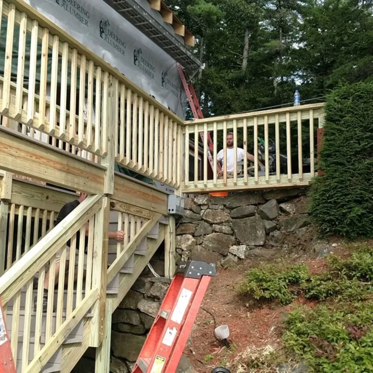 A wooden deck with a ladder on the side of it