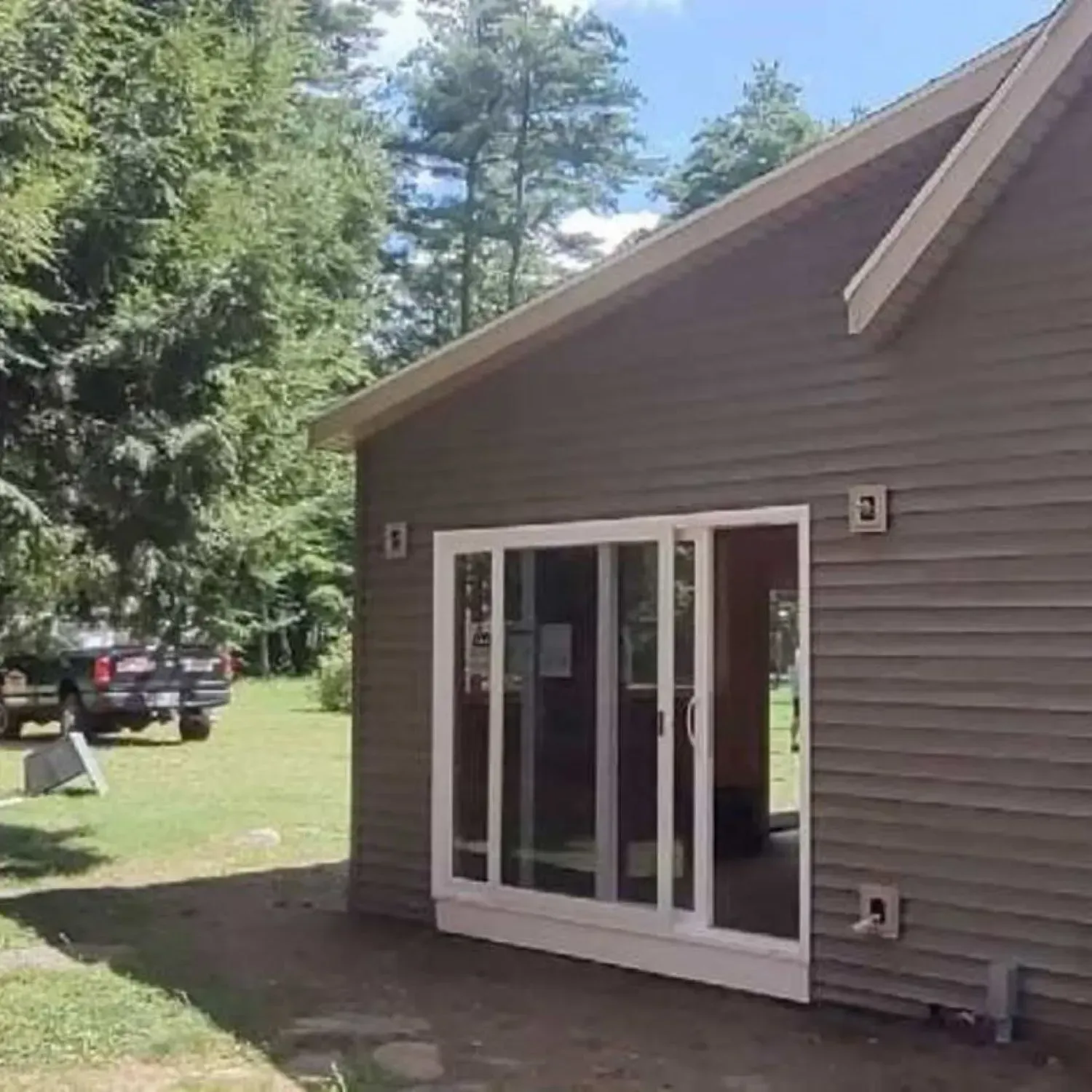 A small house with a sliding glass door in the backyard