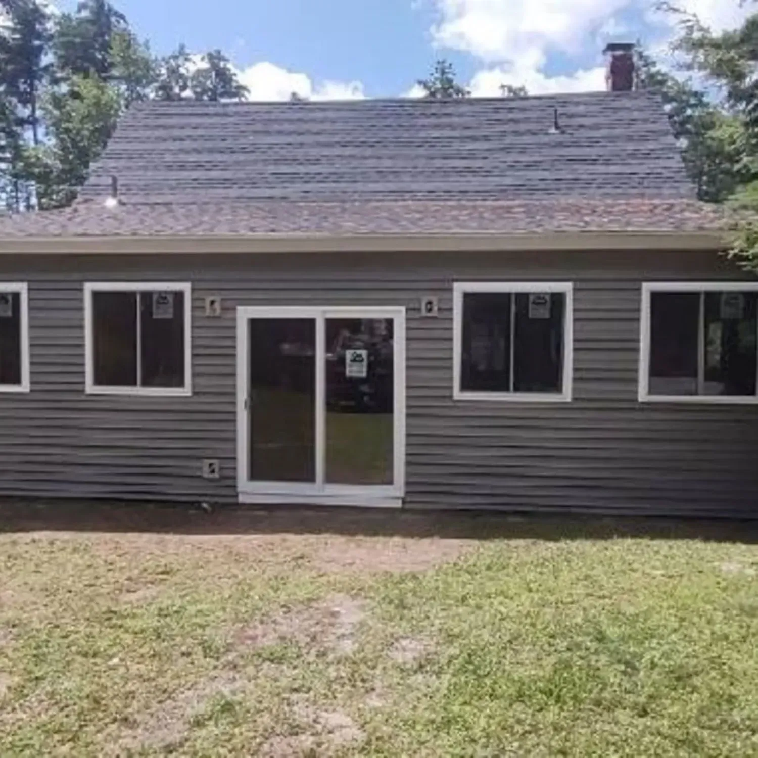 A small house with a lot of windows and a sliding glass door.