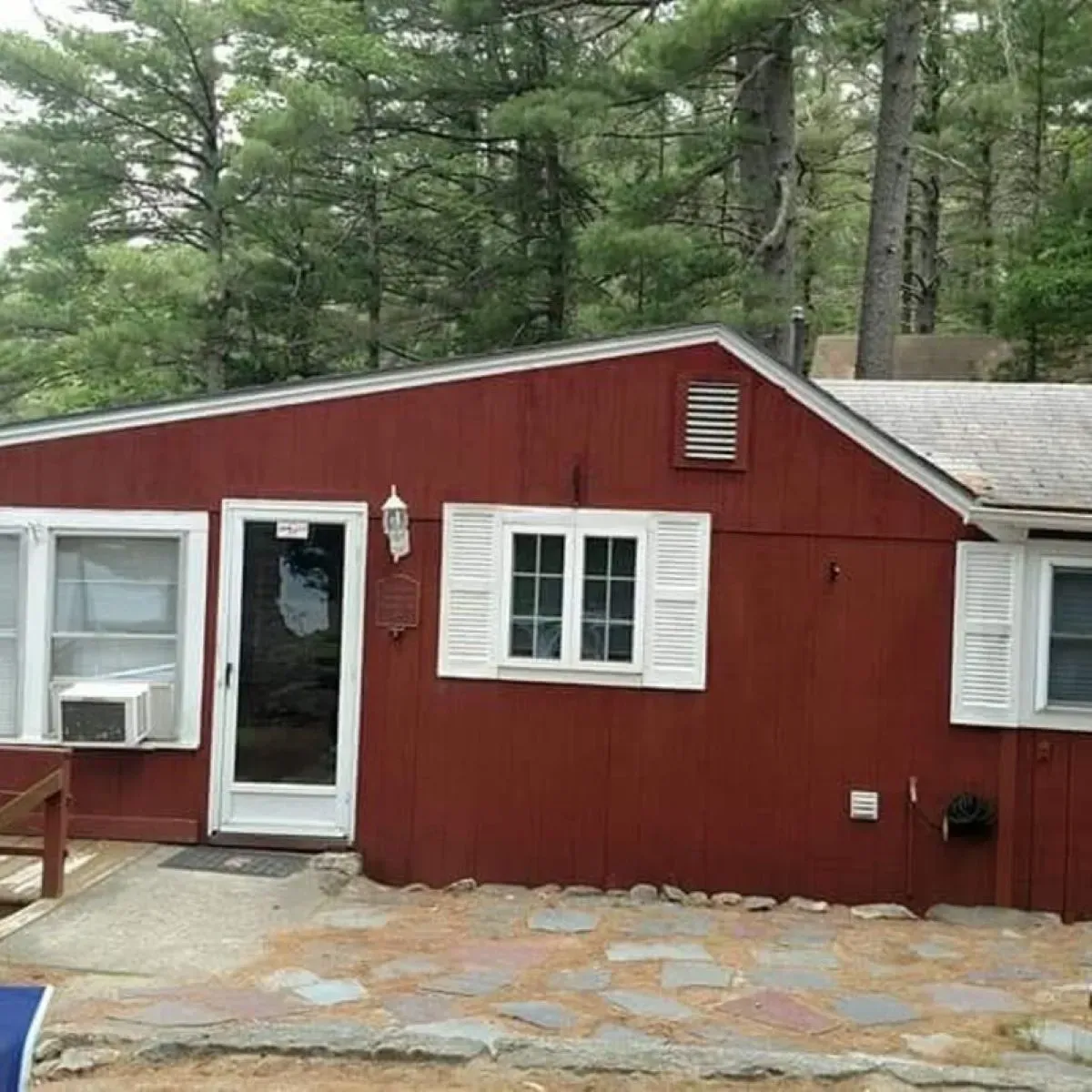 A red house with white shutters on the windows