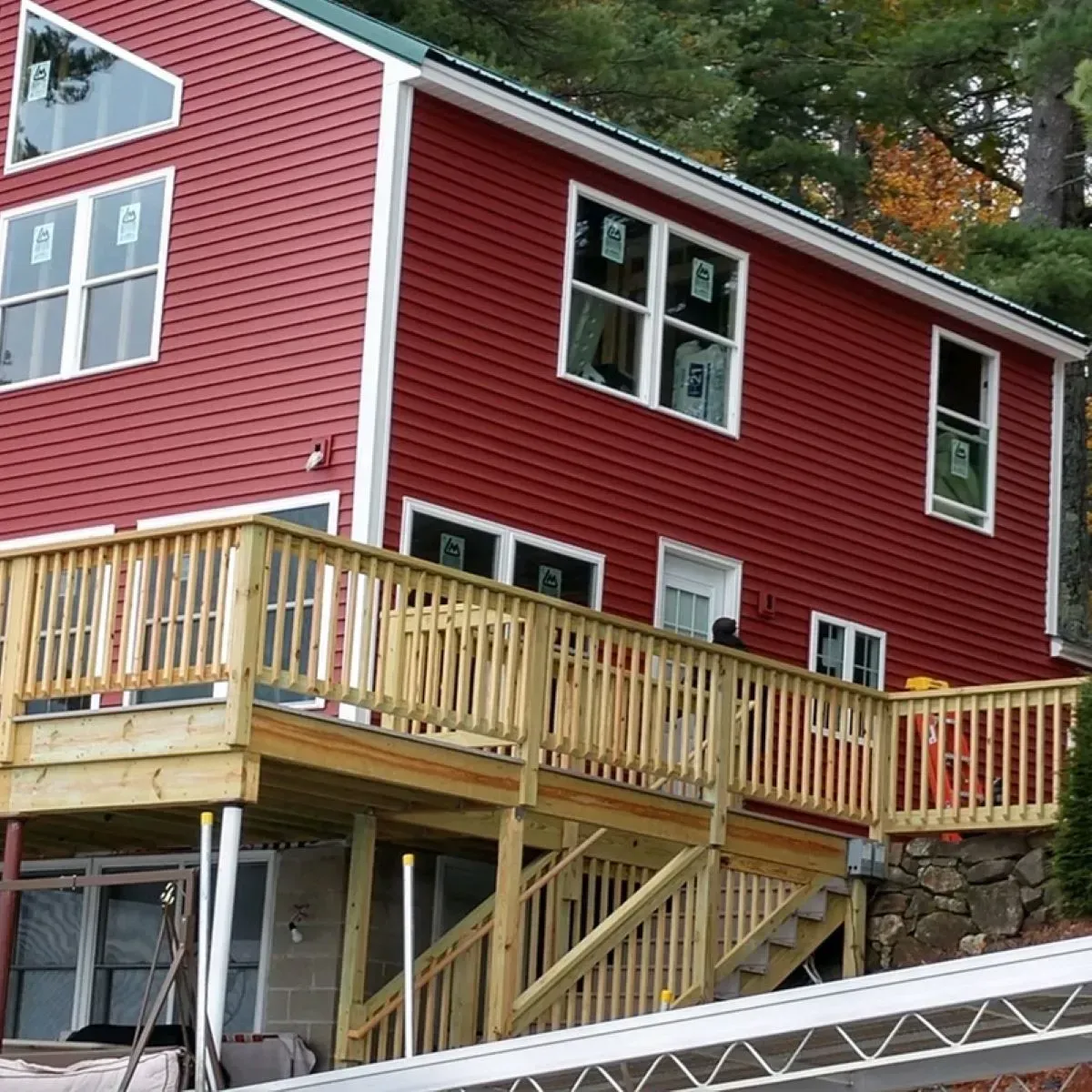 A red house with a wooden deck and stairs