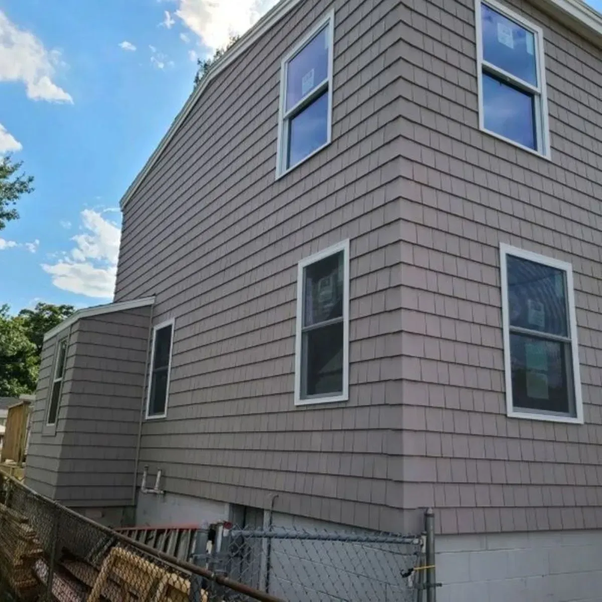 A house with a lot of windows and a chain link fence