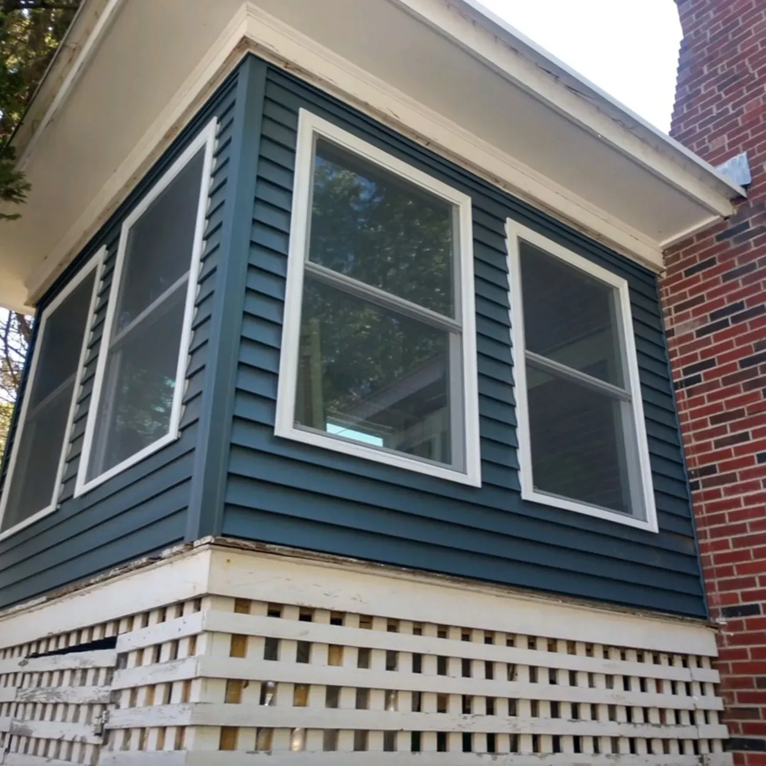 A corner of a house with blue siding and white trim