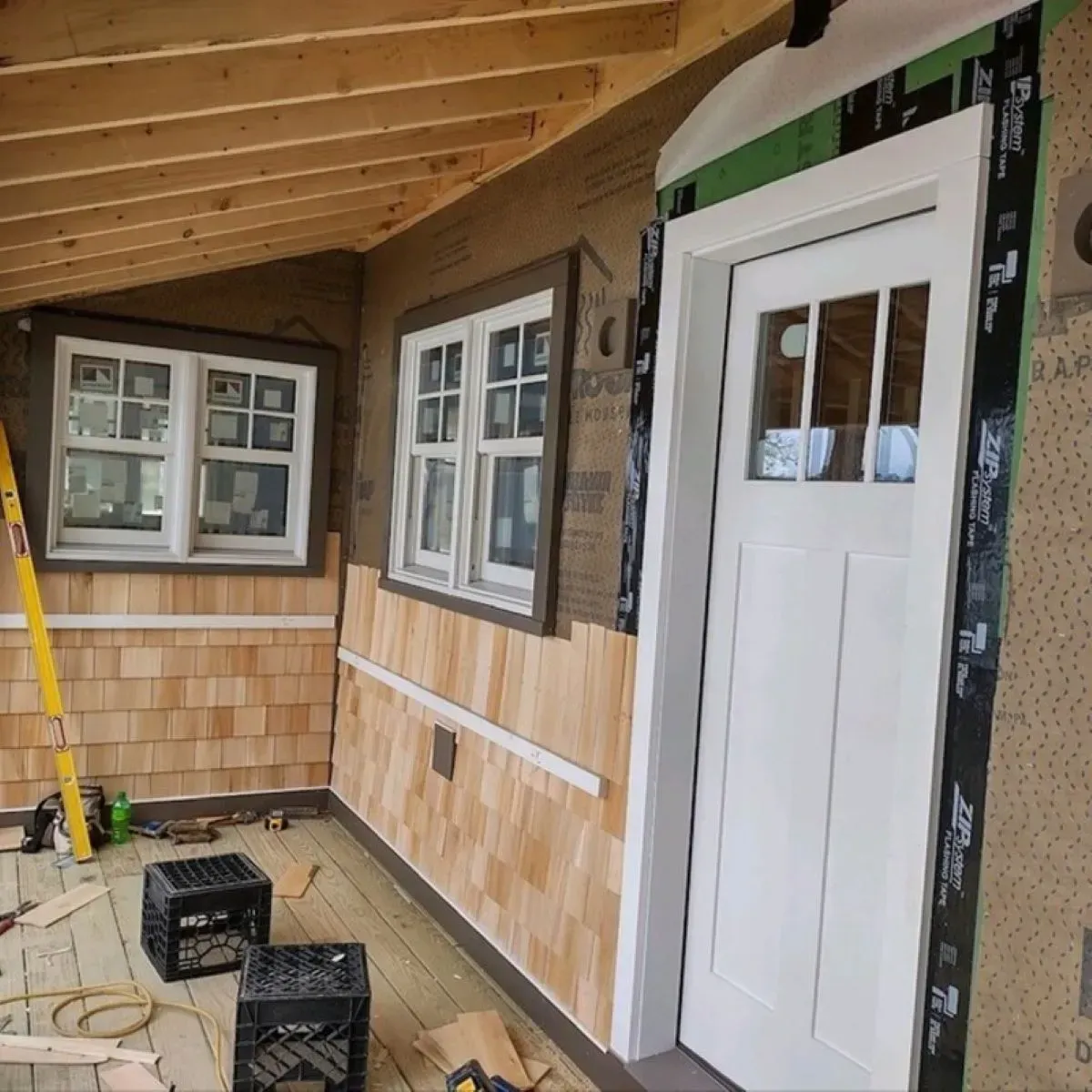 A house under construction with a white door and two windows