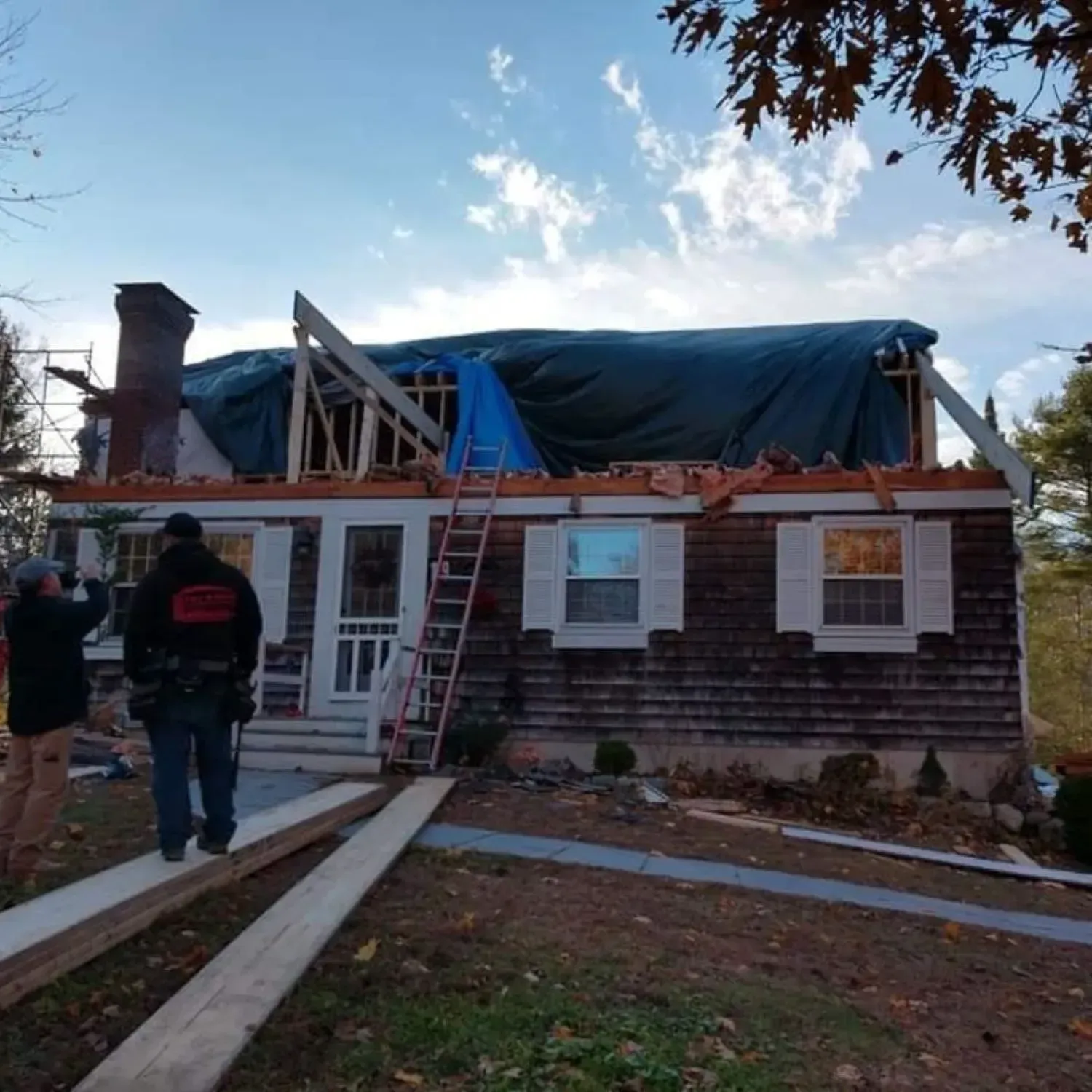 A house under construction with a tarp on the roof