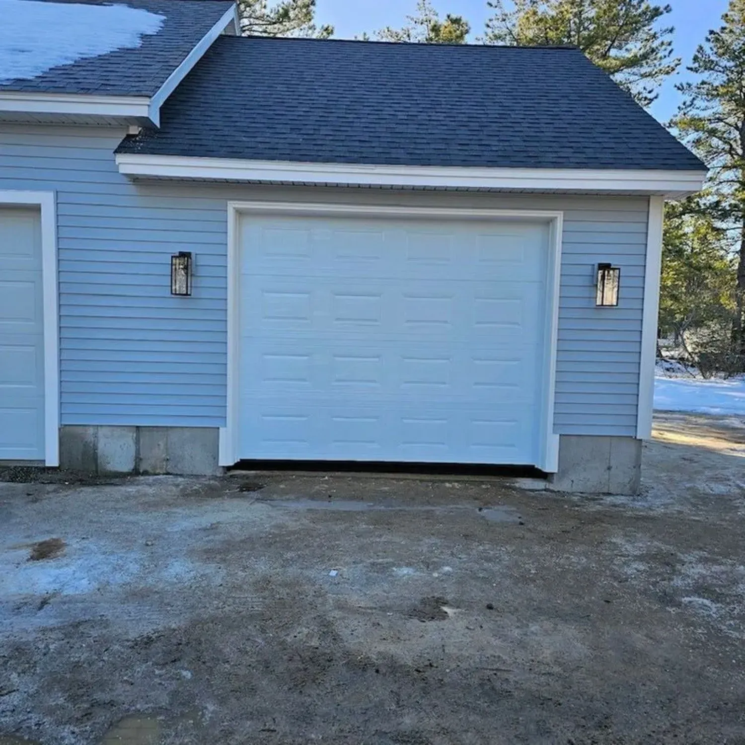 A blue garage with a white door and a black roof