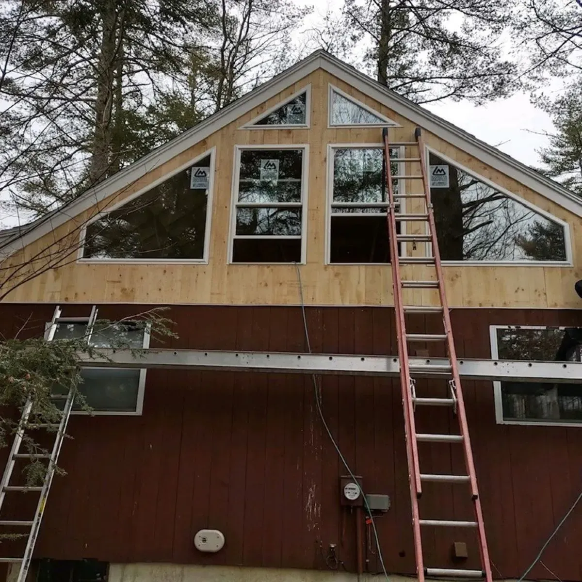 A red house with a ladder on the side of it