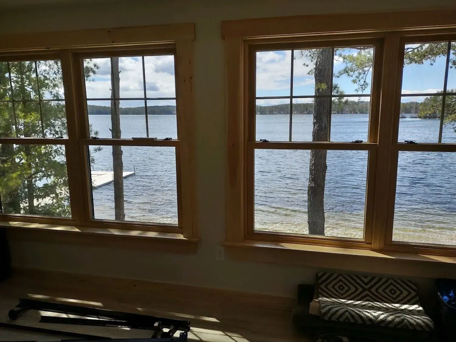 A living room with two windows looking out to a lake