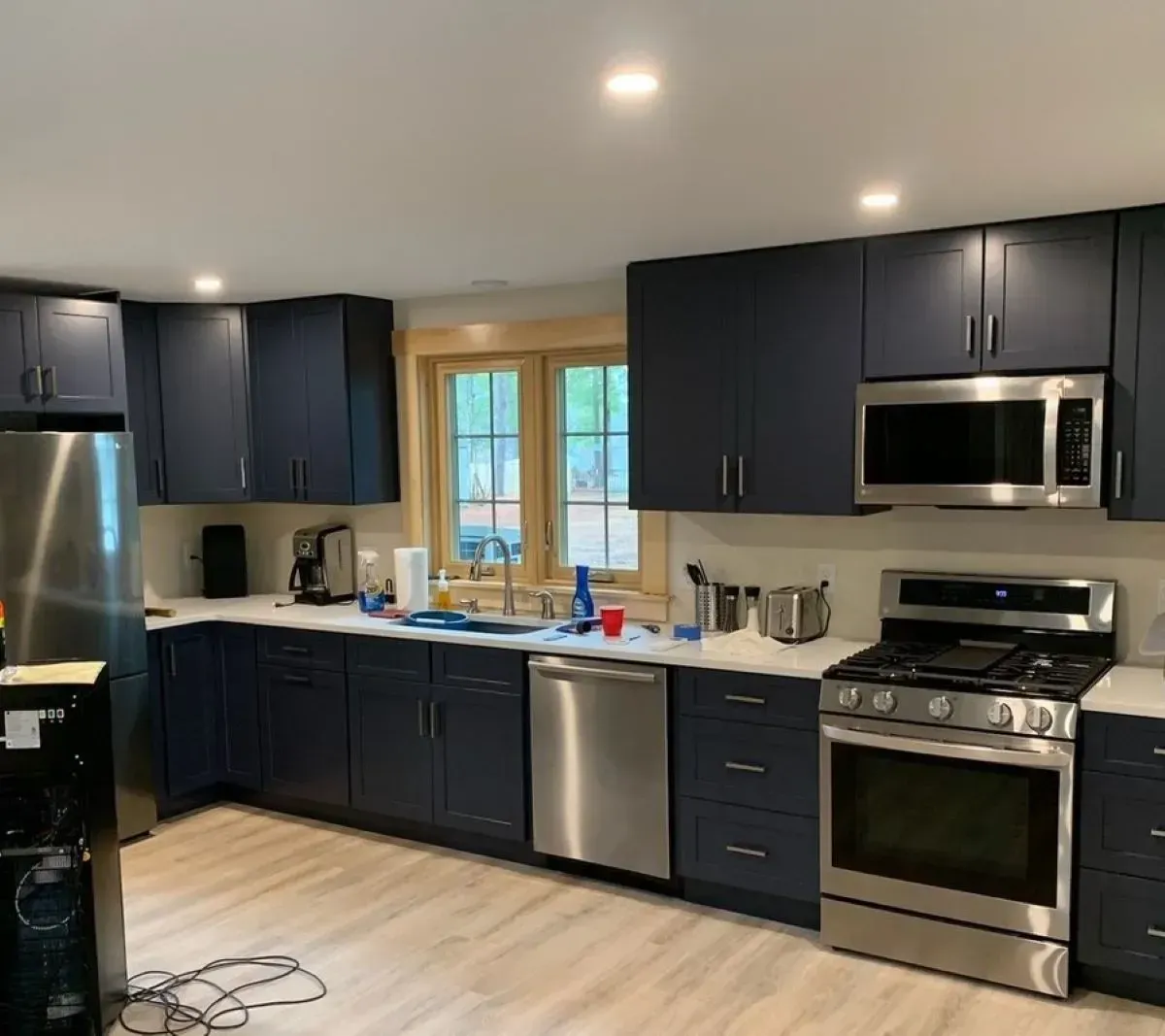 A kitchen with blue cabinets and stainless steel appliances.