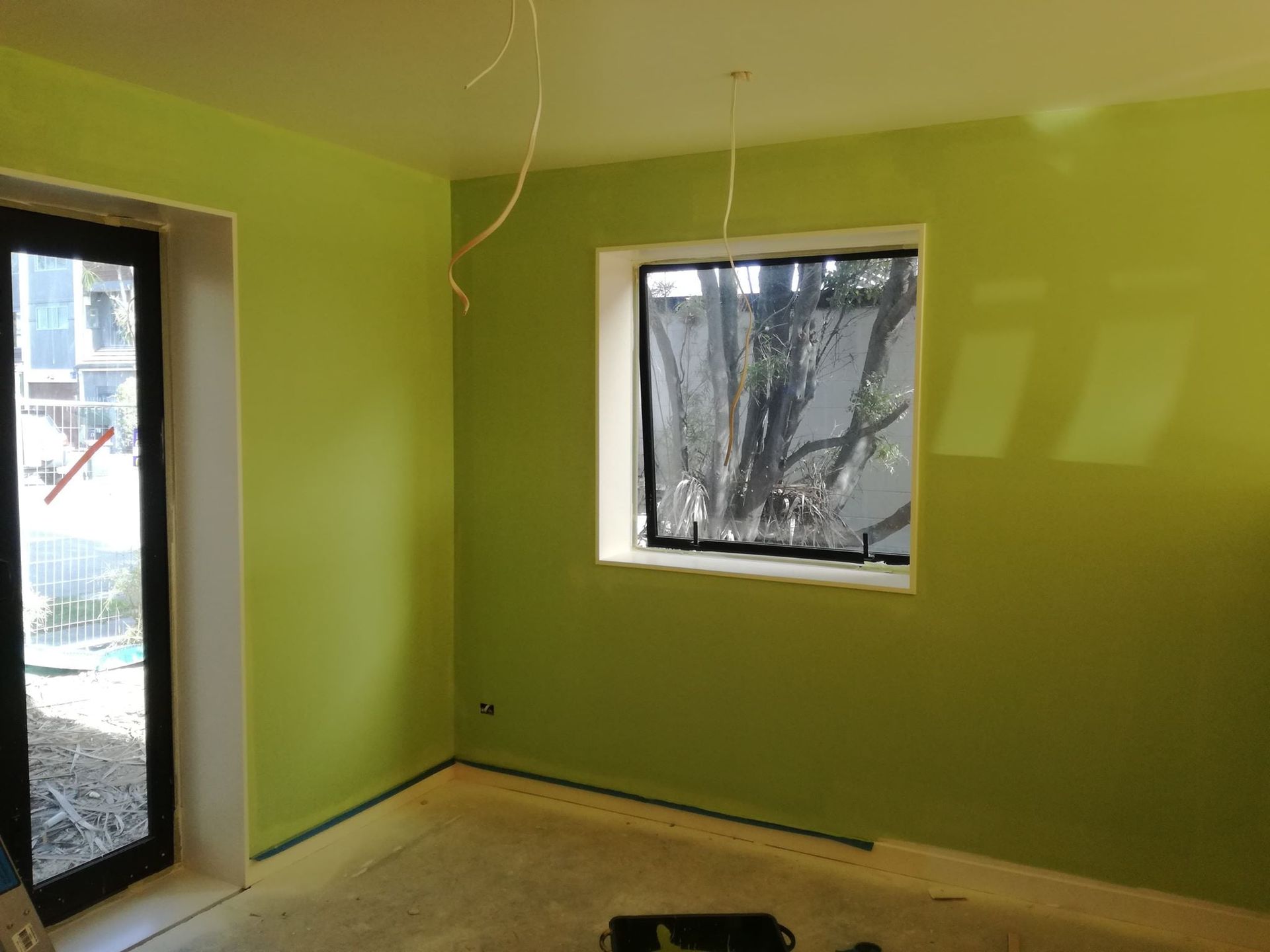 A room with green walls and a window.