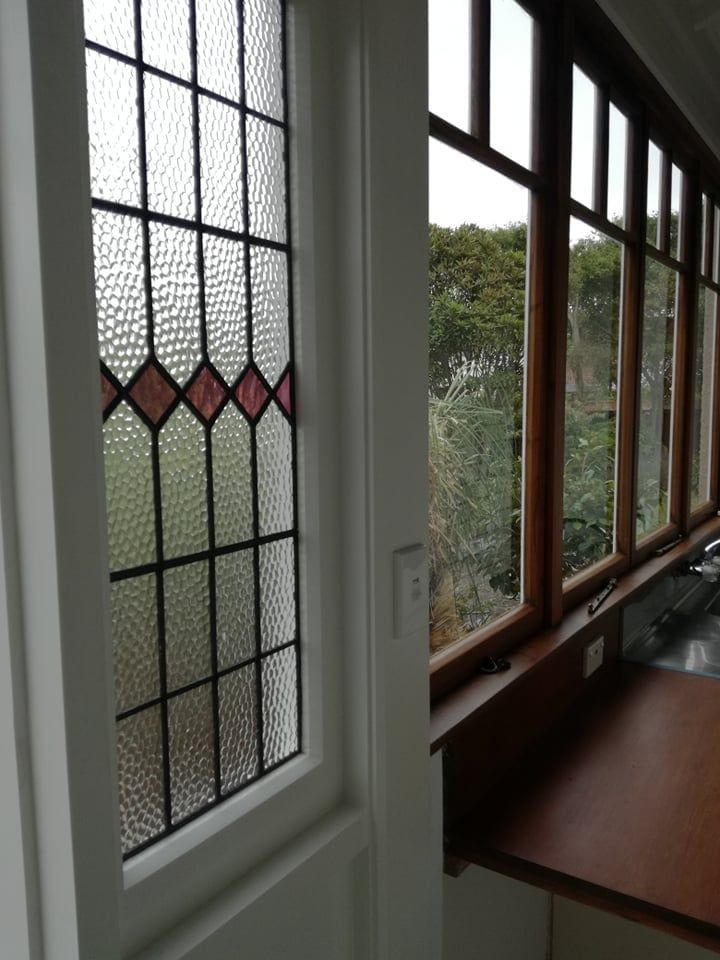 A kitchen with a stained glass window and a sink