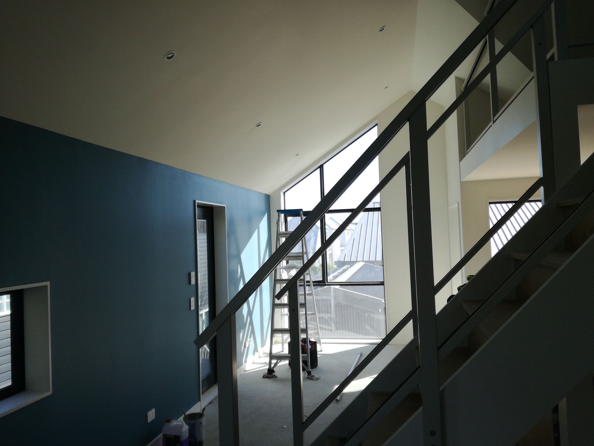 A staircase with a blue wall and a white railing