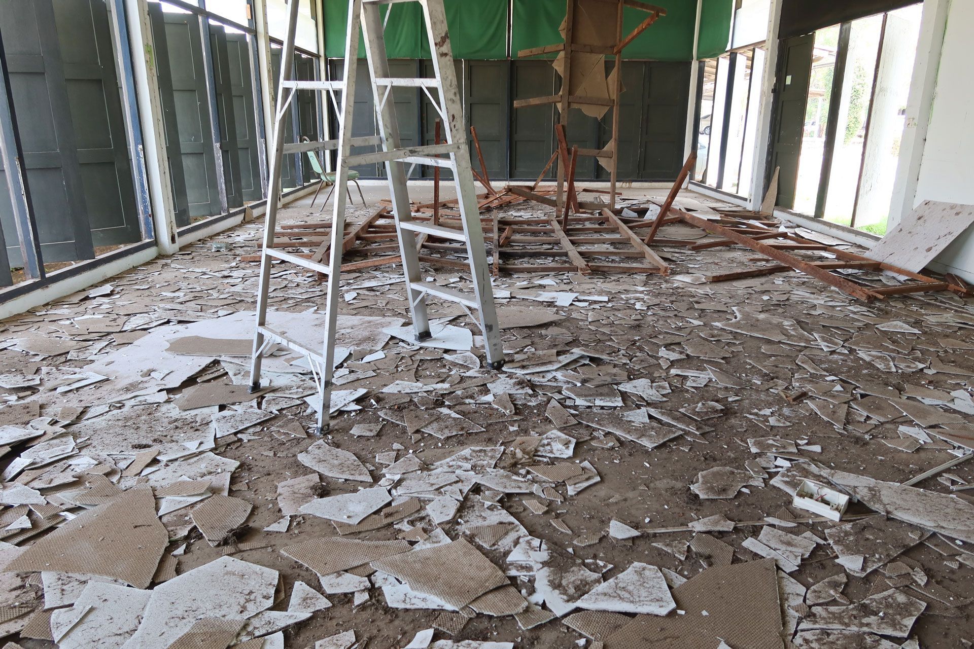 Destroyed room with debris-covered floor and scaffolding in an unfinished interior