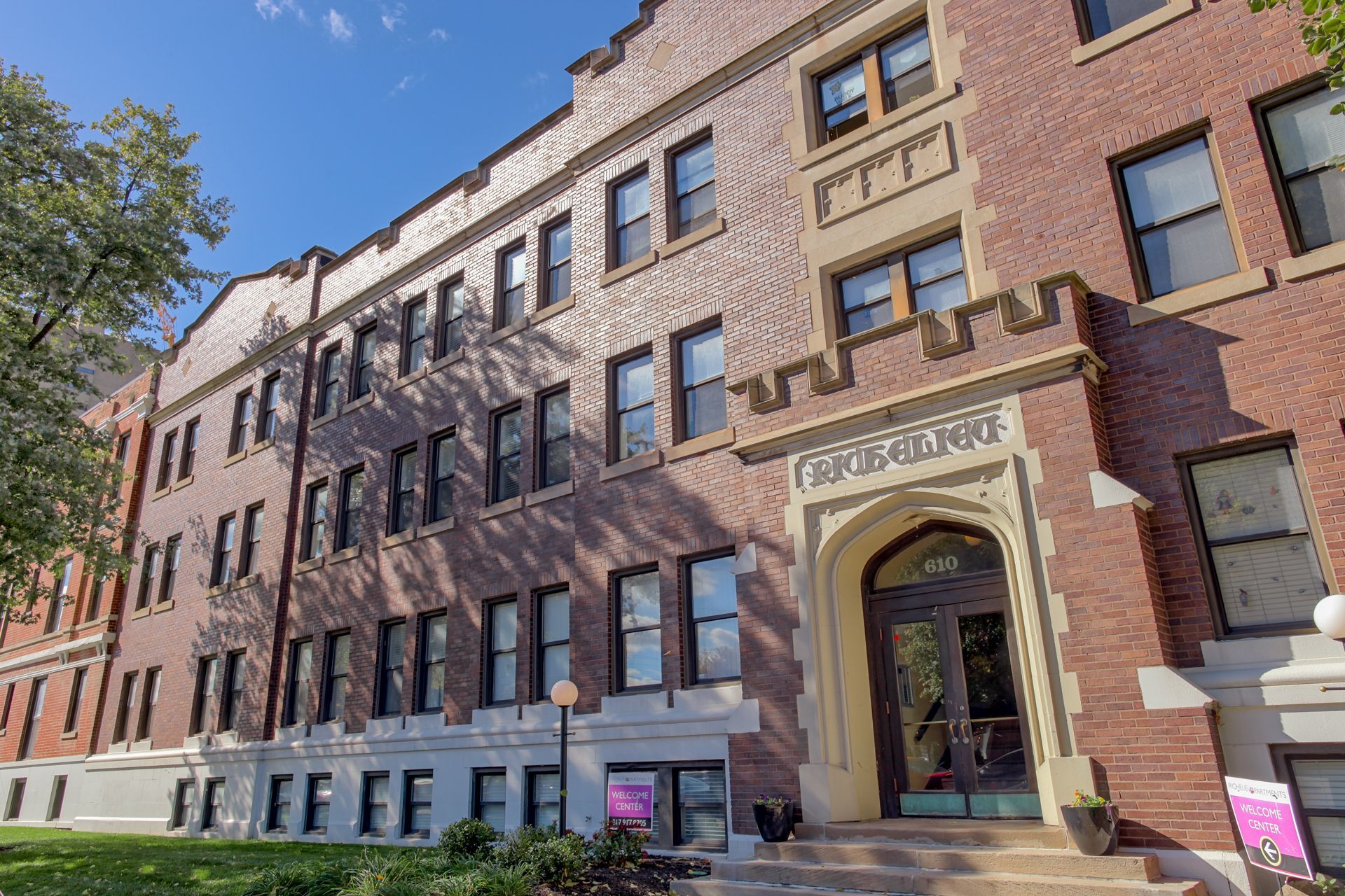 A large brick building with a lot of windows on a sunny day.